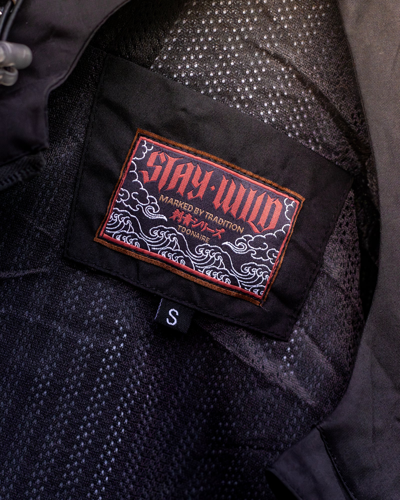 STAY WILD woven label inside Hanya Windbreaker — Marked by Tradition
